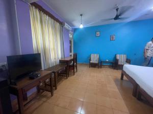 a room with a bed and a tv and some chairs at Hotel White Sand Bache Stay in Aguada +22 photos