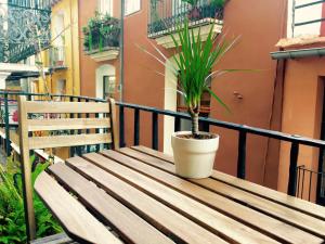 una maceta sentada en un banco de madera en un balcón en Sun Studio Valencia, en Valencia