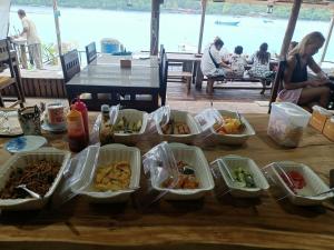 a table with several containers of food on it at Iboih inn in Sabang
