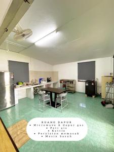 a large room with a table and chairs in it at Harumi Guesthouse in Marang