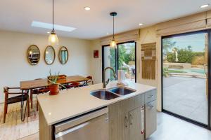a kitchen with a sink and a dining room at Adobe Barona Dream in Palm Springs