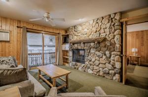 a living room with a stone wall with a fireplace at Superior Shores Resort in Two Harbors