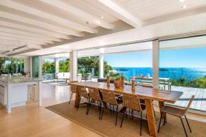 a kitchen and dining room with a large wooden table at No 63 - Stay Waiheke in Onetangi