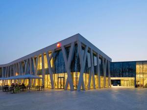 a large building with tables and chairs in front of it at ibis Heverlee Leuven in Leuven