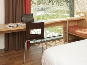 a room with a desk with a laptop computer on it at ibis Heverlee Leuven in Leuven