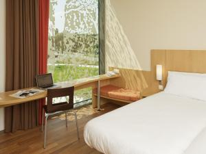 a hotel room with a bed and a desk with a laptop at ibis Heverlee Leuven in Leuven +38 photos