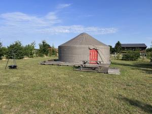 a yurt with a red door in a field at Fermily Lodges in Perrières