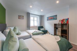 a living room with a bed and a chair at Familien Apartment bei Legoland 8 Min, Spielplatz & Netflix in Ichenhausen