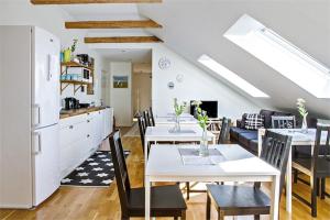 a kitchen and dining room with white tables and chairs at Villa Sandby B&B in Borrby