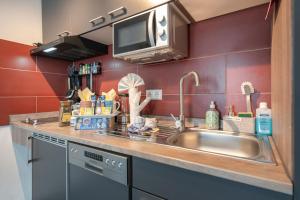 a kitchen counter with a sink and a microwave at Familien Apartment bei Legoland 8 Min, Spielplatz & Netflix in Ichenhausen