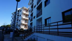 - un immeuble d'appartements blanc avec un éclairage de rue à côté dans l'établissement Apartment Calcada, à Albufeira