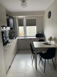a kitchen with a table and chairs and a dining room at Apartament Rubinkowo in Toruń