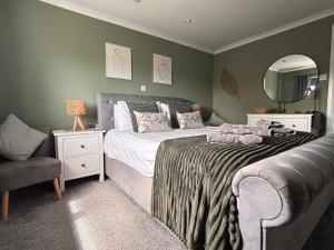 a bedroom with a bed and a chair and a mirror at Craster Crew Quarters in Craster