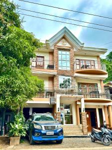 a blue car parked in front of a house at Buena's Haven Travelodge in El Nido
