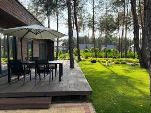 a patio with a table and chairs and an umbrella at Grace Place in Soshnikov