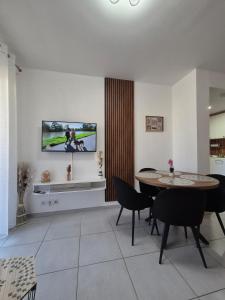 a dining room with a table and a tv on the wall at Charmant T2 in Calvi