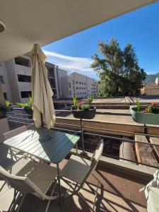 a patio with a table and chairs and an umbrella at Charmant T2 in Calvi