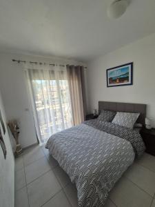a bedroom with a bed and a sliding glass door at Charmant T2 in Calvi