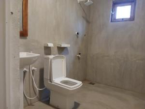 a bathroom with a toilet and a sink at TK Stay in Arugam Bay