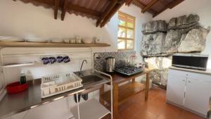 a kitchen with white cabinets and a sink and a counter at Hotel Posada La Vereda in Cuetzalán del Progreso