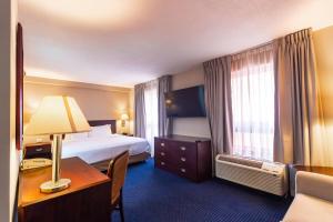 a hotel room with a bed and a desk with a lamp at Wyndham Garden Monterrey Norte in Monterrey