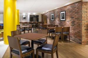 a restaurant with tables and chairs and a brick wall at Wyndham Garden Monterrey Norte in Monterrey
