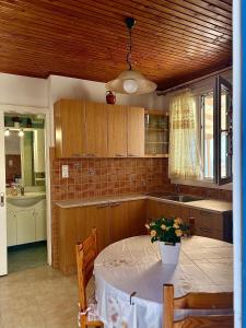 a kitchen with a table with a vase of flowers on it at Lotos Suite in Kini