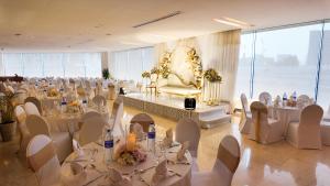a banquet hall with white tables and chairs at Al Bustan Centre & Residence in Dubai