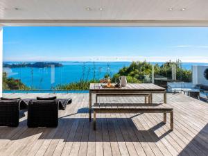 a patio with a table and a view of the water at No 63 - Stay Waiheke in Onetangi