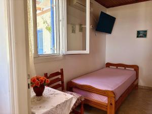 a small room with a table and a bed and a window at Lotos Suite in Kini