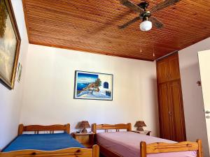 two beds in a bedroom with a ceiling fan at Lotos Suite in Kini