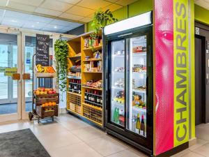 a grocery store aisle with a refrigerator full of food at ibis budget Strasbourg Sud Illkirch in Geispolsheim +103 photos