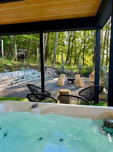 a hot tub with chairs and an elephant in the background at Csuszka Vendégház MÁTRA in Mátraszentimre