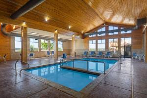 a pool in a large room with a large building at Baymont by Wyndham Oacoma in Oacoma