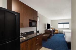 a hotel room with a kitchen and a bedroom at Baymont by Wyndham Oacoma in Oacoma