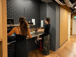 two women standing at a sink in a kitchen at Shijo Guesthouse HIVE in Kyoto