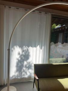 a floor lamp next to a couch in front of a window at Stay Jian in Daegu