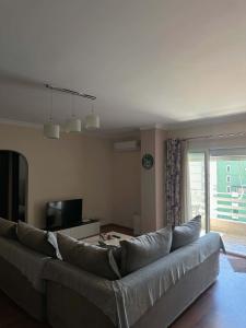 a living room with a large couch and a television at Mollys2apartment in Pogradec