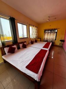 a large bed in a room with two windows at Muthu Seaview Residency in Kuilapayam