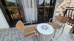 a table and chairs on a balcony with a table at kuza Suites Mbale in Mbale