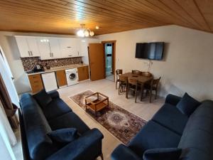 a living room with a blue couch and a table at Long Lake pansiyon in Uzungöl