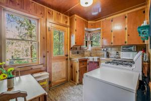 a kitchen with wooden cabinets and a white stove top oven at Walden in the Woods in Idyllwild +9 photos