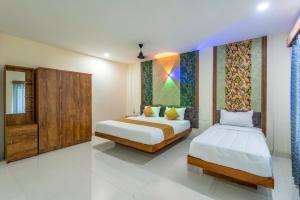 a bedroom with two beds and a painting on the wall at Hotel Beverly Residency - Near Nileshwar Railway Station in Nīleshwar