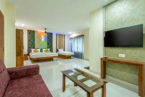 a living room with a couch and a tv at Hotel Beverly Residency - Near Nileshwar Railway Station in Nīleshwar