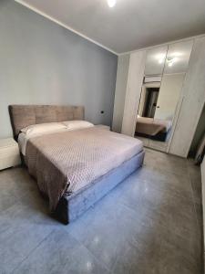 a bedroom with a large bed and a mirror at Residence Parco Castello 1 in Novi Ligure