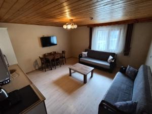 a living room with a couch and a table at Long Lake pansiyon in Uzungöl