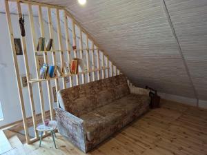 a couch sitting in a room with a staircase at Sielanka na Kociewiu in Skrzynia
