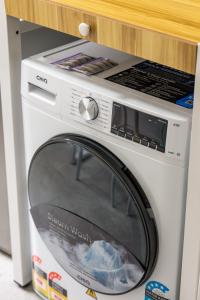 a white washing machine sitting in a cabinet at Canvas On Barkly Apartments St Kilda in Melbourne