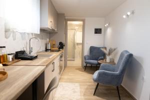a kitchen with two blue chairs and a sink at Εlysian III in Mavrovouni +4 photos