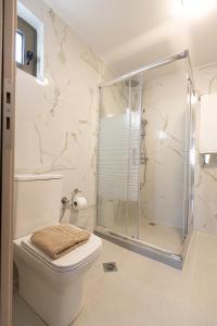 a white bathroom with a shower and a toilet at Εlysian III in Mavrovouni